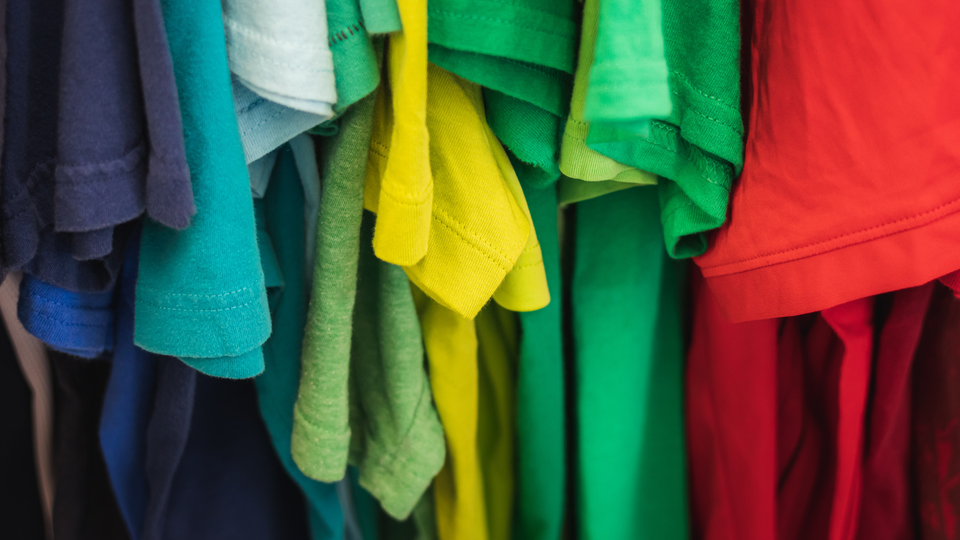 T-shirts in many colours hanging side by side